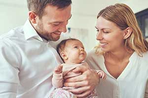 Couple holding baby, investing in a 529 college savings plan