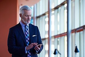 a business man using his phone to contact financial consultants about possibly making 401(k) contributions