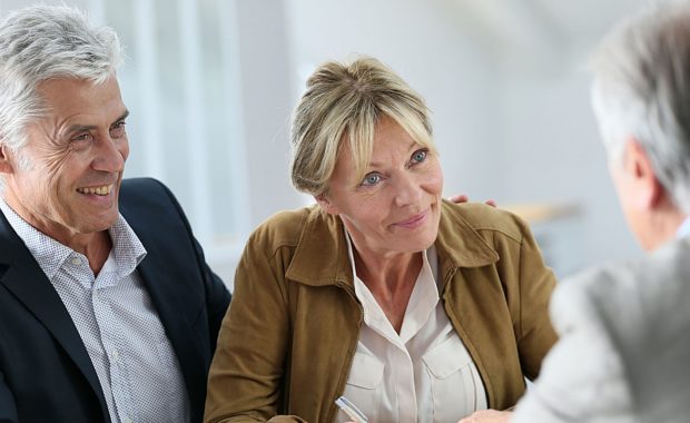 a retired couple working with a retirement plans consultant to discuss the multiple 401(k) retirement plans they can choose from