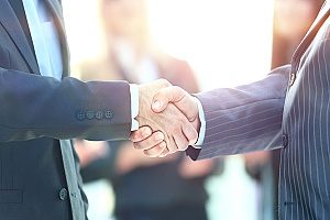 a handshake between a financial consultant and a local business owner who will be discussing retirement plans and how they work for small businesses