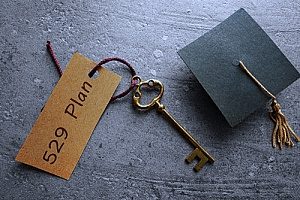 a cap and gown with a key to represent a 529 college savings plan provided by financial consultants