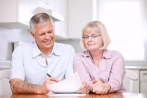 an elderly couple who are reading over their retirement plans that they recently signed up for