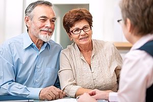 financial consultants speaking with an elderly couple about retirement plans